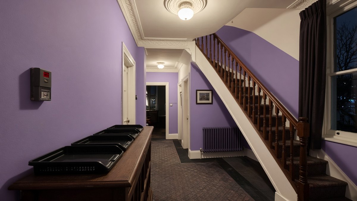 Communal hallway of a shared house with lights on in winter